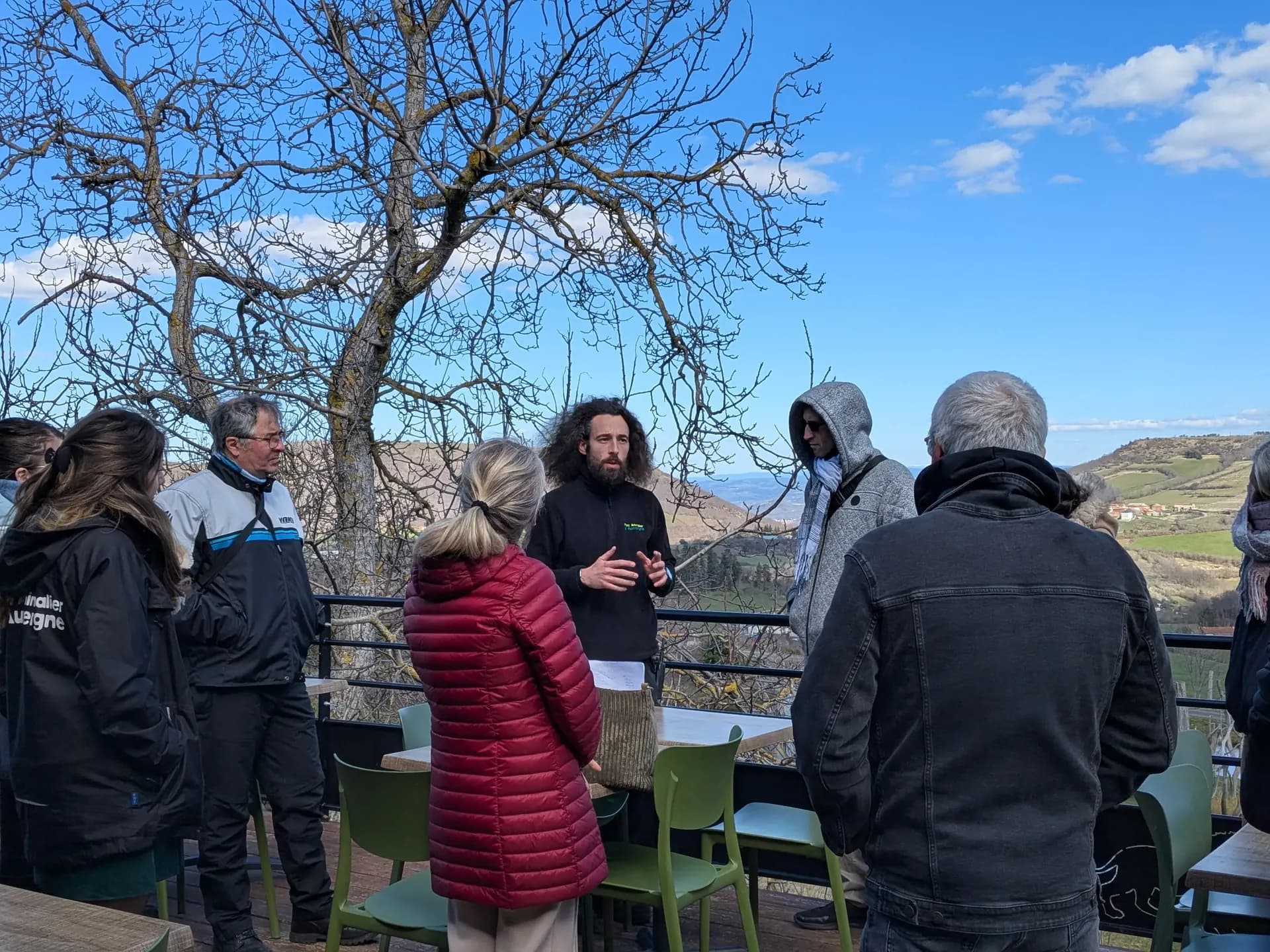 Un groupe écoute les explications d’un guide, sur une terrasse du Parc Animalier d’Auvergne